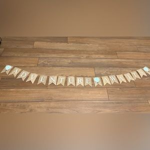 “Adventure Awaits” banner